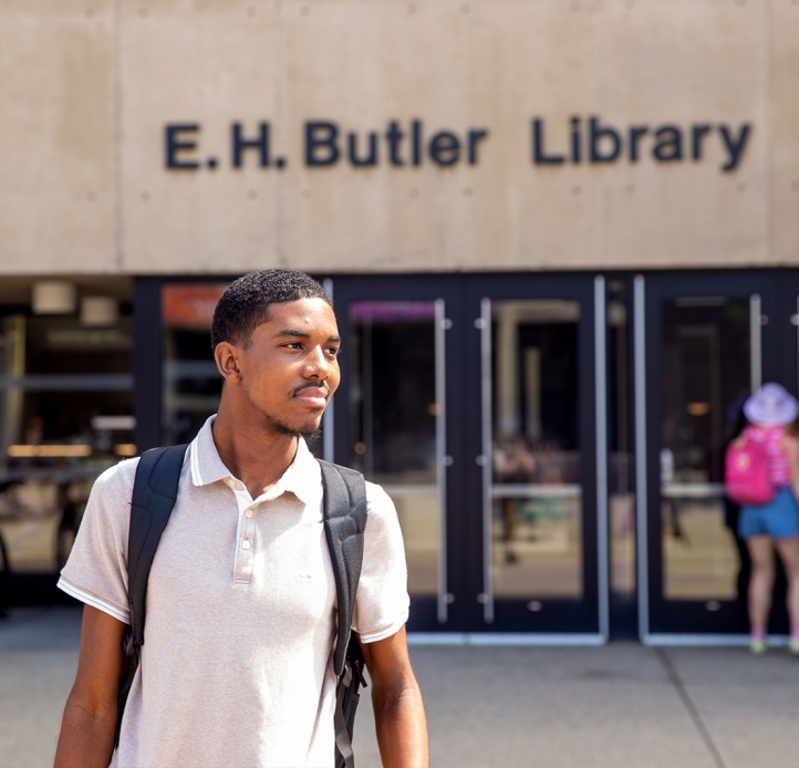 Student walking in front of the library